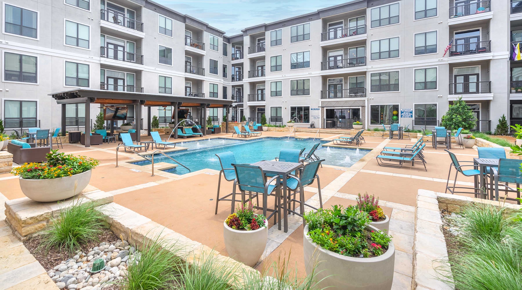 WELCOME TO SEVILLE UPTOWN tables, chairs and loungers surround outdoor pool