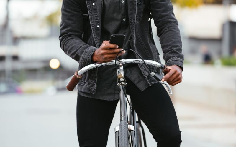 a person on a bicycle holding a phone